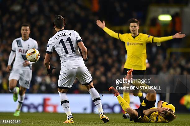 Borussia Dortmund's German defender Marcel Schmelzer falls to the floor after a clash with Tottenham Hotspur's Argentinian midfielder Erik Lamela...