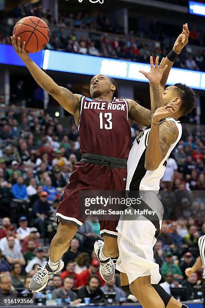 Marcus Johnson Jr. #13 of the Arkansas Little Rock Trojans makes a shot over Vince Edwards of the Purdue Boilermakers during the first round of the...