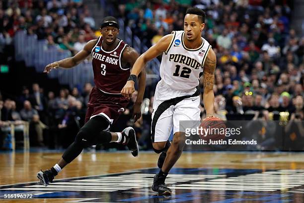 Vince Edwards of the Purdue Boilermakers drives the ball past Josh Hagins of the Arkansas Little Rock Trojans during the first round of the 2016 NCAA...