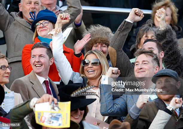 Katie Price cheers as she watches the racing on day 3, St Patrick's Day, of the Cheltenham Festival on March 17, 2016 in Cheltenham, England.