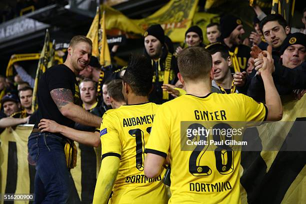 Borussia Dortmund players celebrate victory with their fans after the UEFA Europa League round of 16, second leg match between Tottenham Hotspur and...