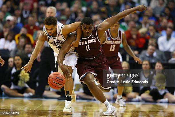 Roger Woods of the Arkansas Little Rock Trojans and P.J. Thompson of the Purdue Boilermakers fight for a ball during the first round of the 2016 NCAA...