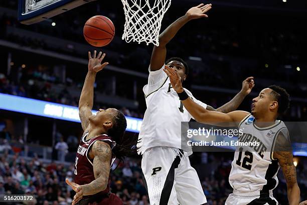 Marcus Johnson Jr. #13 of the Arkansas Little Rock Trojans makes a shot over Johnny Hill of the Purdue Boilermakers during the first round of the...