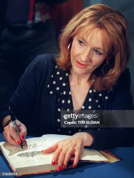 Rowling, author of the best-selling Harry Potter children's books autographs one of her works during a book signing 20 October, 1999 in Washington,...