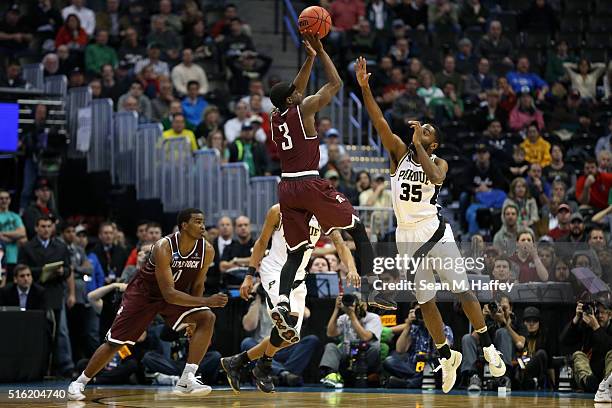 Josh Hagins of the Arkansas Little Rock Trojans makes a shot over Rapheal Davis of the Purdue Boilermakers during the first round of the 2016 NCAA...