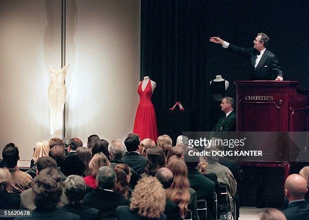 Christie's auctioneer Lord Hindlip gestures towards Marilyn Monroe's "Happy Birthday Mr. President Dress," which Monroe wore while she sang happy...