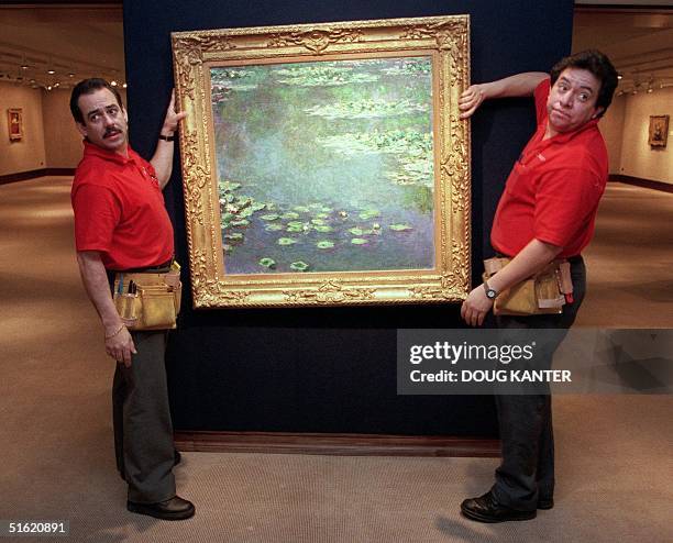Christie's auction house employees Richie Quintana and Marco Cuellar hang Claude Monet's "Nympheas" in New York 04 November 1999. The painting is...