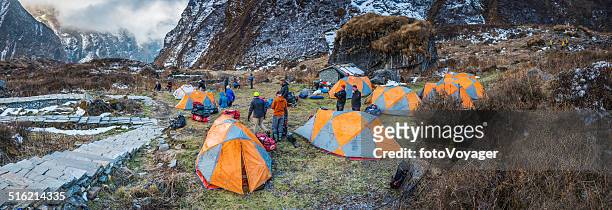mountaineers and sherpas setting up camp annapurna panorama himalayas nepal - base camp stock pictures, royalty-free photos & images