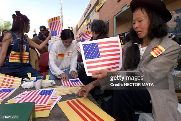 Group of Vietnamese-American volunteers distribute US and Vietnamese flags to demonstrators near the entrance of a video shop 27 February in Little...