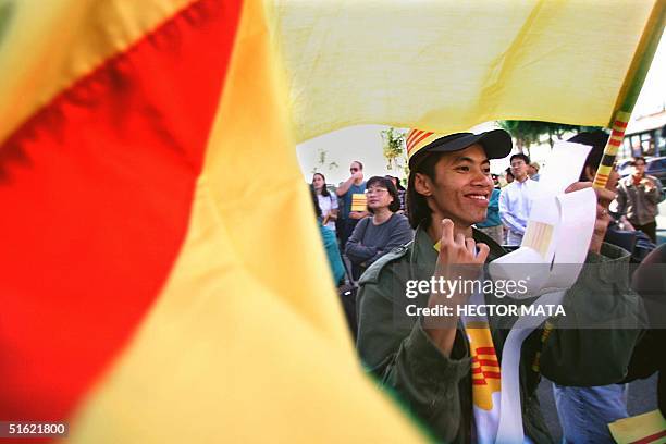 Hung Nguyen, a Vietnamese immigrant, holds a flag of a former Vietnamese regime near the entrance of a video shop 27 February in Little Saigon,...