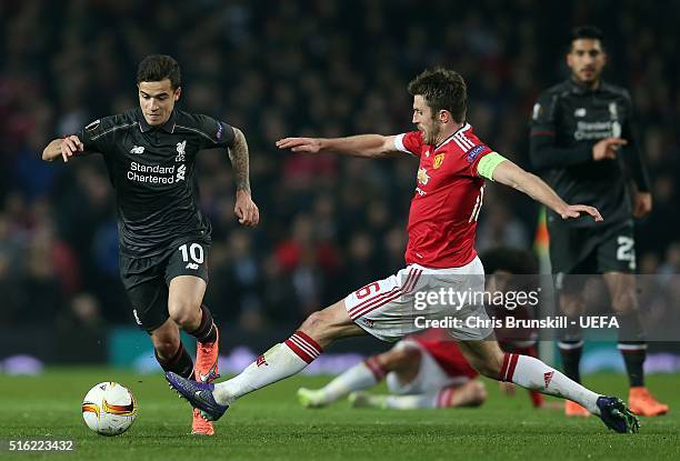 Michael Carrick of Manchester United challenges Philippe Coutinho of Liverpool during the UEFA Europa League round of 16 second leg match between...