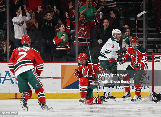 Devante Smith-Pelly of the New Jersey Devils celebrates his goal at 43 seconds of the first period against the Minnesota Wild and is joined by John...