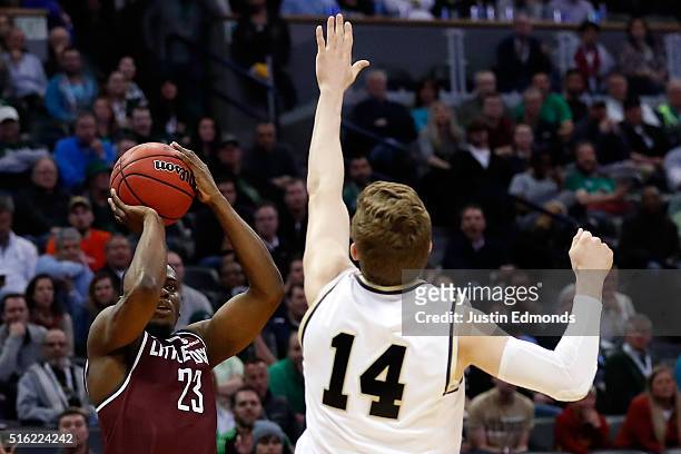 Kemy Osse of the Arkansas Little Rock Trojans makes a three point shot over Ryan Cline of the Purdue Boilermakers in overtime during the first round...