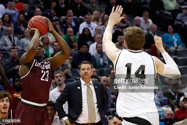 Kemy Osse of the Arkansas Little Rock Trojans makes a three point shot over Ryan Cline of the Purdue Boilermakers in overtime during the first round...