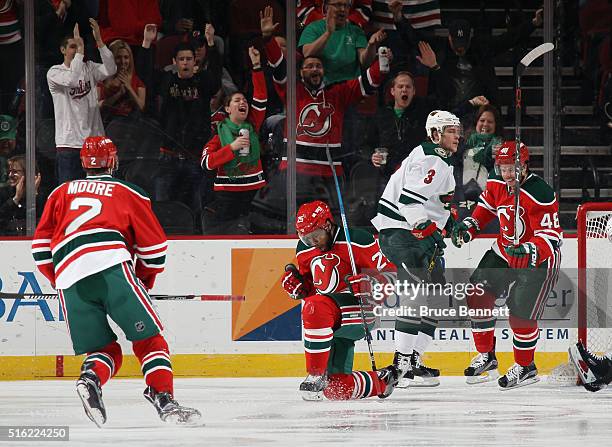 Devante Smith-Pelly of the New Jersey Devils celebrates his goal at 43 seconds of the first period against the Minnesota Wild and is joined by John...