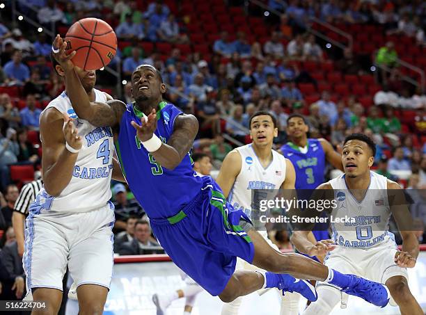 Zach Johnson of the Florida Gulf Coast Eagles dives to shoot the ball in the first half against Isaiah Hicks of the North Carolina Tar Heels during...