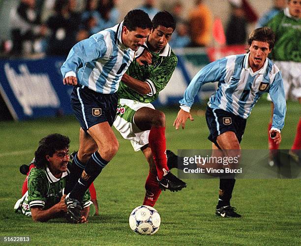 Diego Cagna and Guillermo Barros Schellotto of Argentina battle for control of the ball with Miguel Zepeda of Mexico during an exhibition game 10...