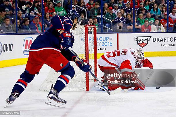 Jimmy Howard of the Detroit Red Wings covers up the puck before Nick Foligno of the Columbus Blue Jackets can get to the rebound during the second...