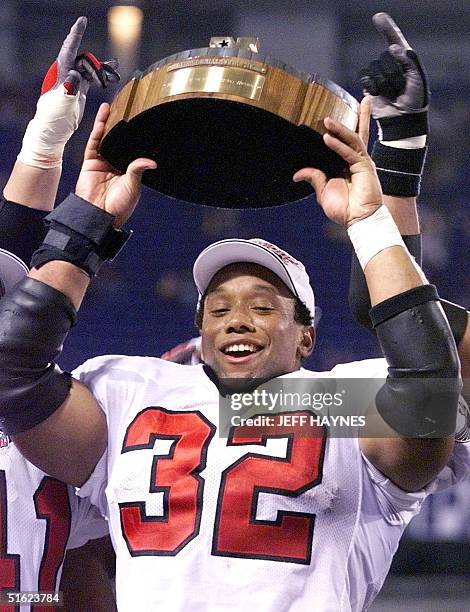 Running back Jamal Anderson of the Atlanta Falcons celebrates with the George S. Halas trophy after winning in overtime against the Minnesota Vikings...