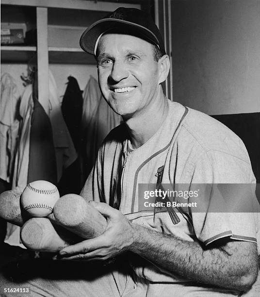 American baseball player Enos Slaughter , outfielder for the St. Louis Cardinals, poses with his bats and the ball that represents his 2000th hit,...