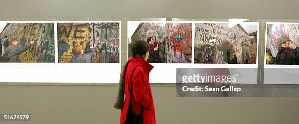Young woman looks at photographs of the Berlin Wall on the opening night of the exhibition "Grenzenlos " by photojournalist Gilles Peress October 29,...