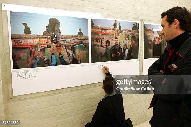 Visitors look at photographs of the Berlin Wall on the opening night of the exhibition "Grenzenlos " by photojournalist Gilles Peress October 29,...