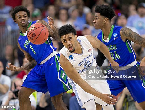 North Carolina's Joel Berry II chases a loose ball with Florida Gulf Coast's Reggie Reid and Rayjon Tucker during the first half in the first round...