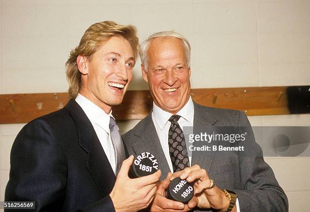 Gordie Howe and Wayne Gretzky of the Los Angeles Kings hold pucks with the number of career points after Gretzky broke Howe's career points record...
