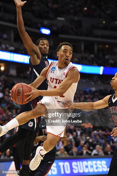 Utah Utes guard Brandon Taylor flies under the basket as he makes a pass to the outside past Fresno State Bulldogs guard Lionel Ellison III in the...