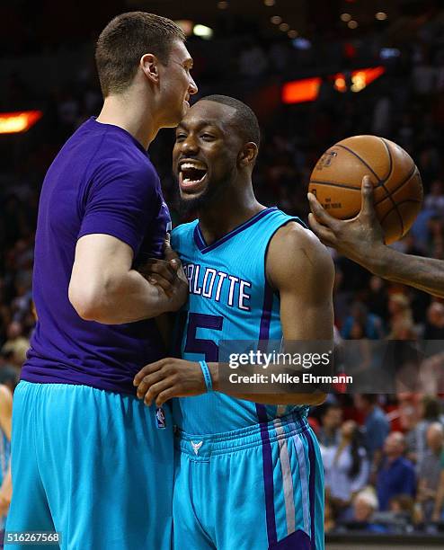 Kemba Walker and Tyler Hansbrough of the Charlotte Hornets celebrate winning a game against the Miami Heat at American Airlines Arena on March 17,...