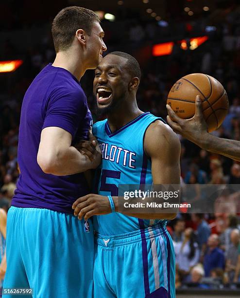 Kemba Walker and Tyler Hansbrough of the Charlotte Hornets celebrate winning a game against the Miami Heat at American Airlines Arena on March 17,...