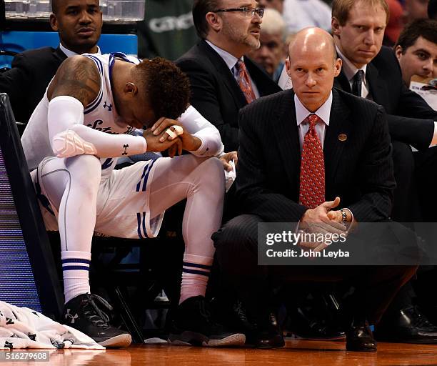 Seton Hall Pirates guard Derrick Gordon holds his head down in dejection as he sits at the end of the bench and Seton Hall Pirates head coach Kevin...