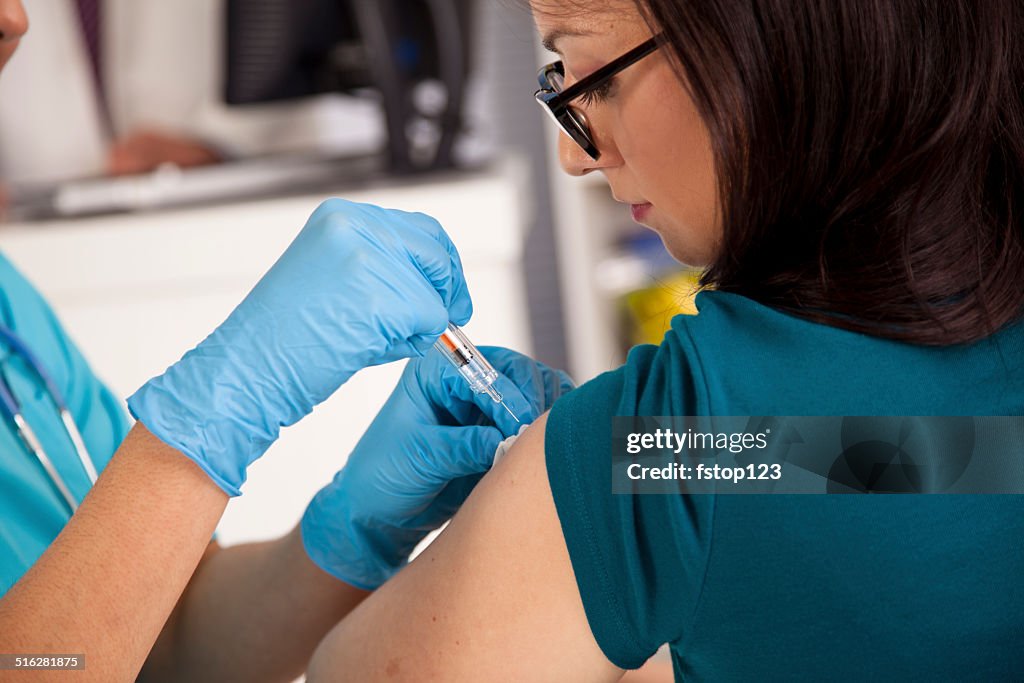 Medical: Nurse at pharmacy clinic giving flu shot to patient.