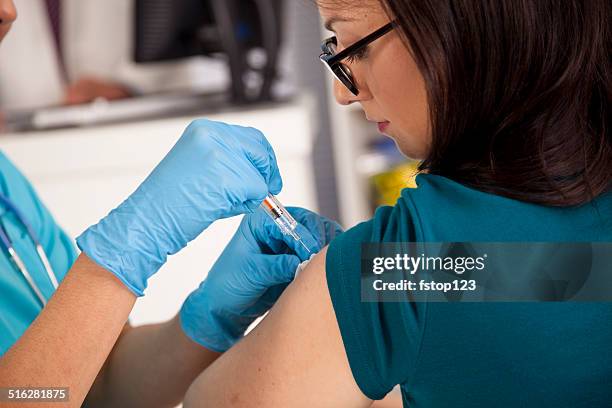 medical: nurse at pharmacy clinic giving flu shot to patient. - flu vaccine stock pictures, royalty-free photos & images