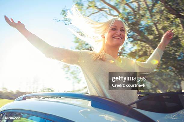 woman enjoying the freedom of a sun roof - sunroof stock pictures, royalty-free photos & images