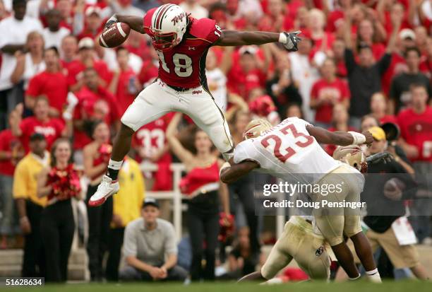 Vernon Davis of the University of Maryland Terrapins leaps over the defense of Bryant McFadden and Jerome Carter of the Florida State Seminoles...