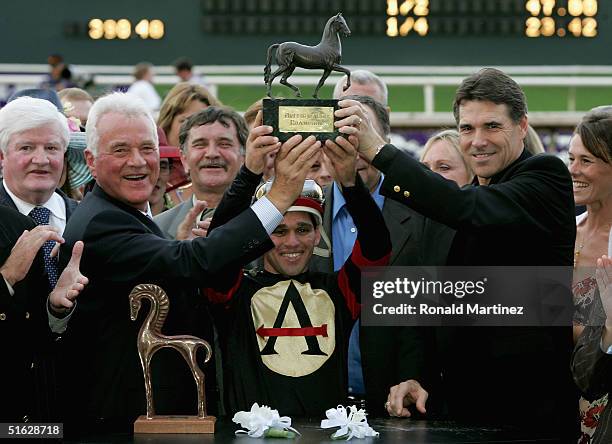 Jockey Javier Castellano holds the trophy with Governor of Texas, Rick Perry , trainer of Ghostzapper, Robert J. Frankel and owner, Frank Stronach in...