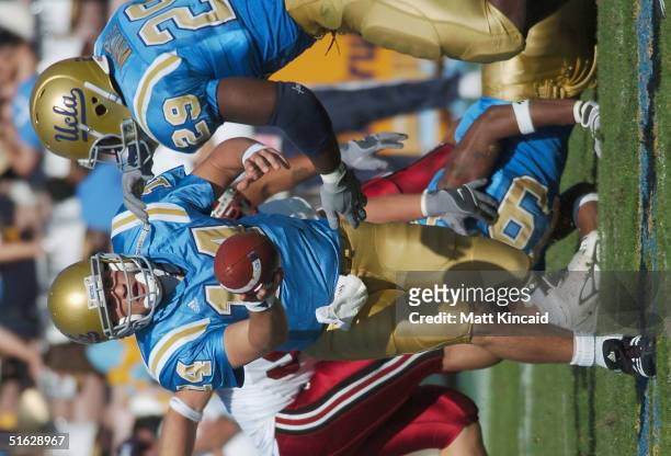 Quarterback Drew Olson hands the ball off to Manuel White of the UCLA Bruins during the game against the Stanford University Cardinals at the Rose...