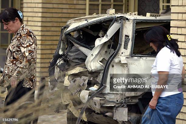 Women walk past the wreckage of vehicles following a car bomb outside the villa housing the Dubai-based Al-Arabiya satellite television station...