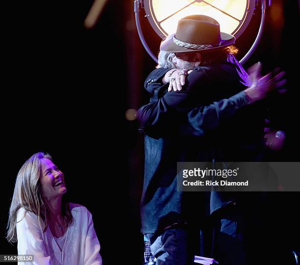 Hank Williams Jr. And Kris Kristofferson hug while Lisa Kristofferson looks on at The Life & Songs of Kris Kristofferson produced by Blackbird...