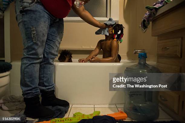 Nakeyja Cade bathes her three children in boiled bottled water after her one-year-old daughter Zariyah Cade had a blood test scoring high in lead...