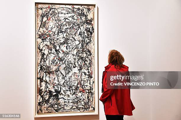 Visitor looks at the "Enchanted forest" by US painter Jackson Pollock during a press preview of the exhibition "From Kandinsky to Pollock, the art of...