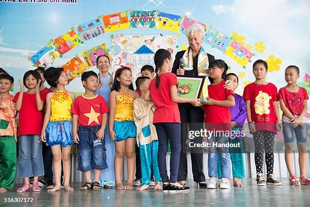 In this handout photo provided by the International Monetary Fund , International Monetary Fund Managing Director Christine Lagarde visits children...