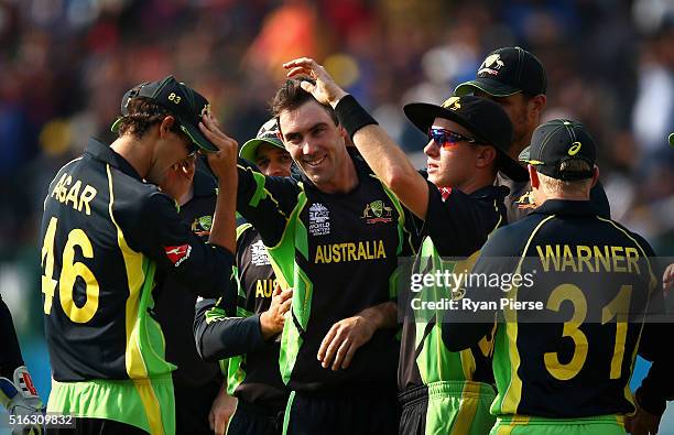 Ashton Agar and Glenn Maxwell of Australia celebrates after combining to taking the wicket of Corey Anderson of New Zealand during the ICC World...