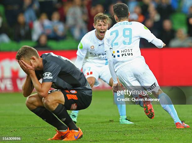 Anthony Caceres and Nick Fitzgerald of City celebrate a goal as Daniel Bowles of the Roar looks dejected during the round 24 A-League match between...