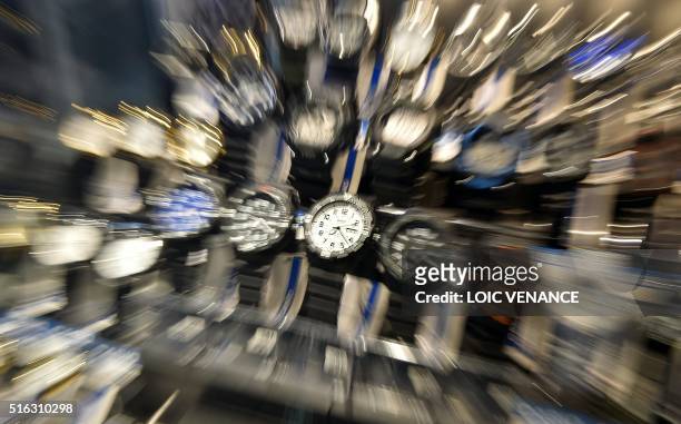 Picture taken on March 17, 2016 shows watches in a store window in Nantes, western France. - France will change to daylight saving time on March 27,...