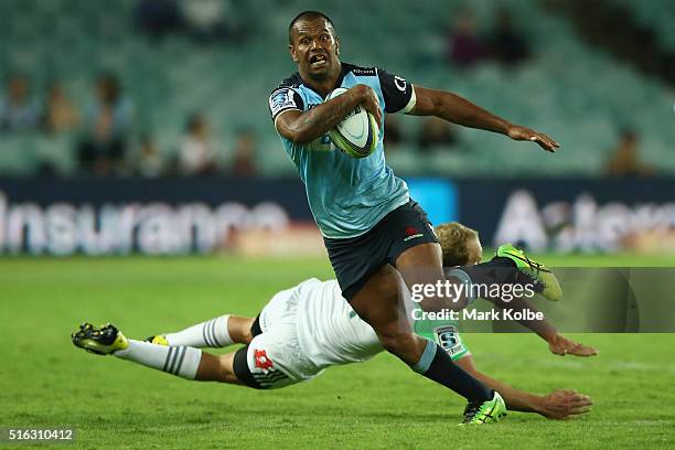 Kurtley Beale of the Waratahs beats the tackle of Matt Faddes of the Highlanders during the Super Rugby match between the New South Wales Waratahs...
