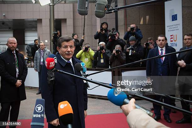 Turkey's Prime Minister, Ahmet Davutoglu, speaks to the media as he arrives at the Council of the European Union on the second day of an EU summit,...