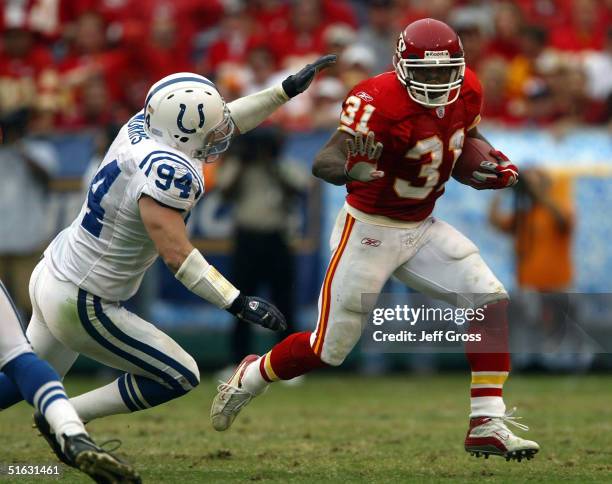 Running back Priest Holmes of the Kansas City Chiefs carries the ball while being pursued by linebacker Rob Morris of the Indianapolis Colts on...