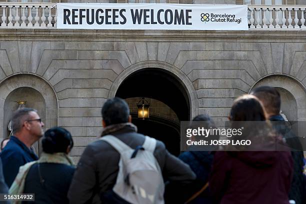 Banner reading "Refugees Welcome" hangs on the facade of the Barcelona's City Hall, on March 18, 2016 days after Barcelona's mayor Ada Colau,...